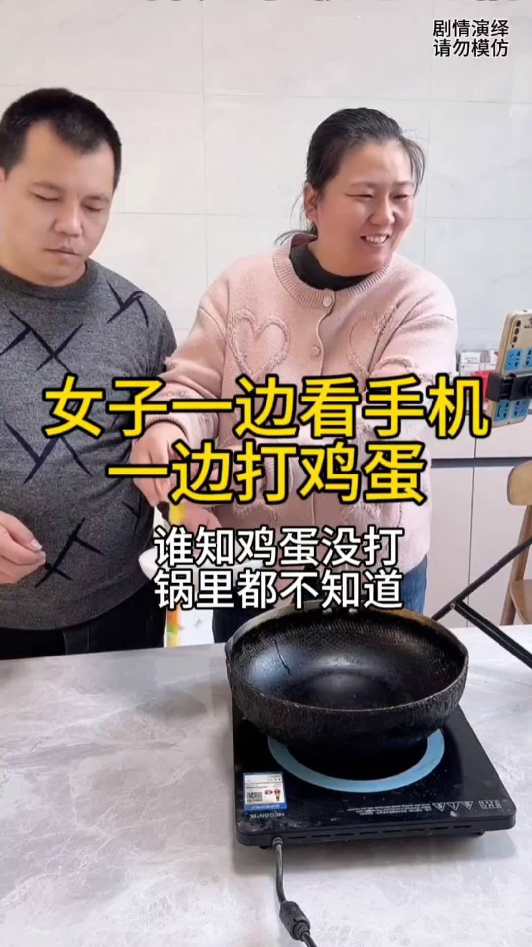 女子一边看手机一边打鸡蛋，谁知鸡蛋没打锅里都不知道。
女子正在厨房做饭，这时她准