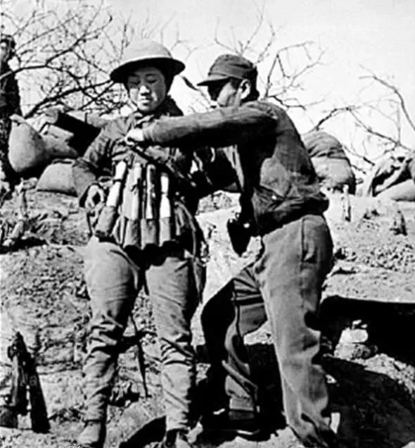 这张照片，是美国摄影师罗伯特·卡帕拍摄于1938年的台儿庄战役，而这名绑满手榴弹