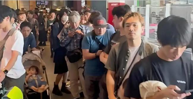 东京涩谷街头，一群日本人凌晨六点就开始排队，有人从大阪驱车赶来，自备小板凳，一站