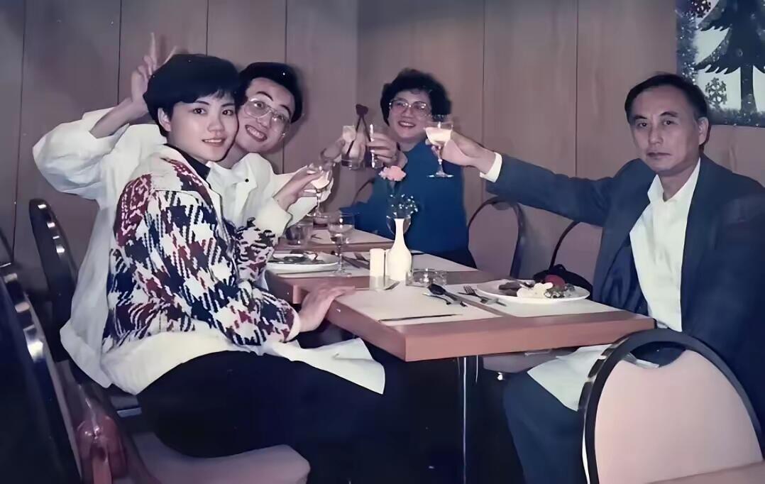 这是拍于90年代的老照片，王菲和家人聚餐时的情景，当时的王菲留着短发造型，全家人