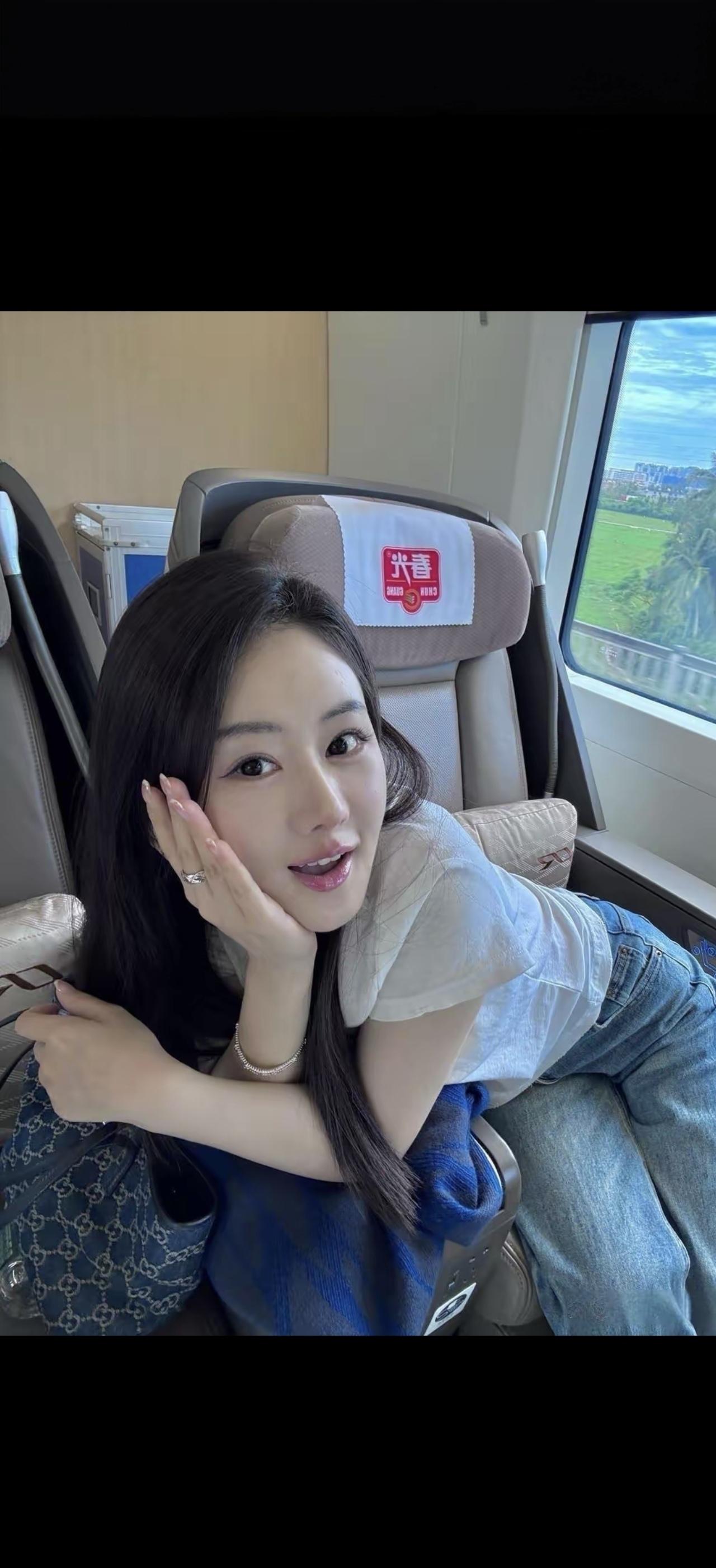 这姑娘在火车上靠着座位，看着窗外。