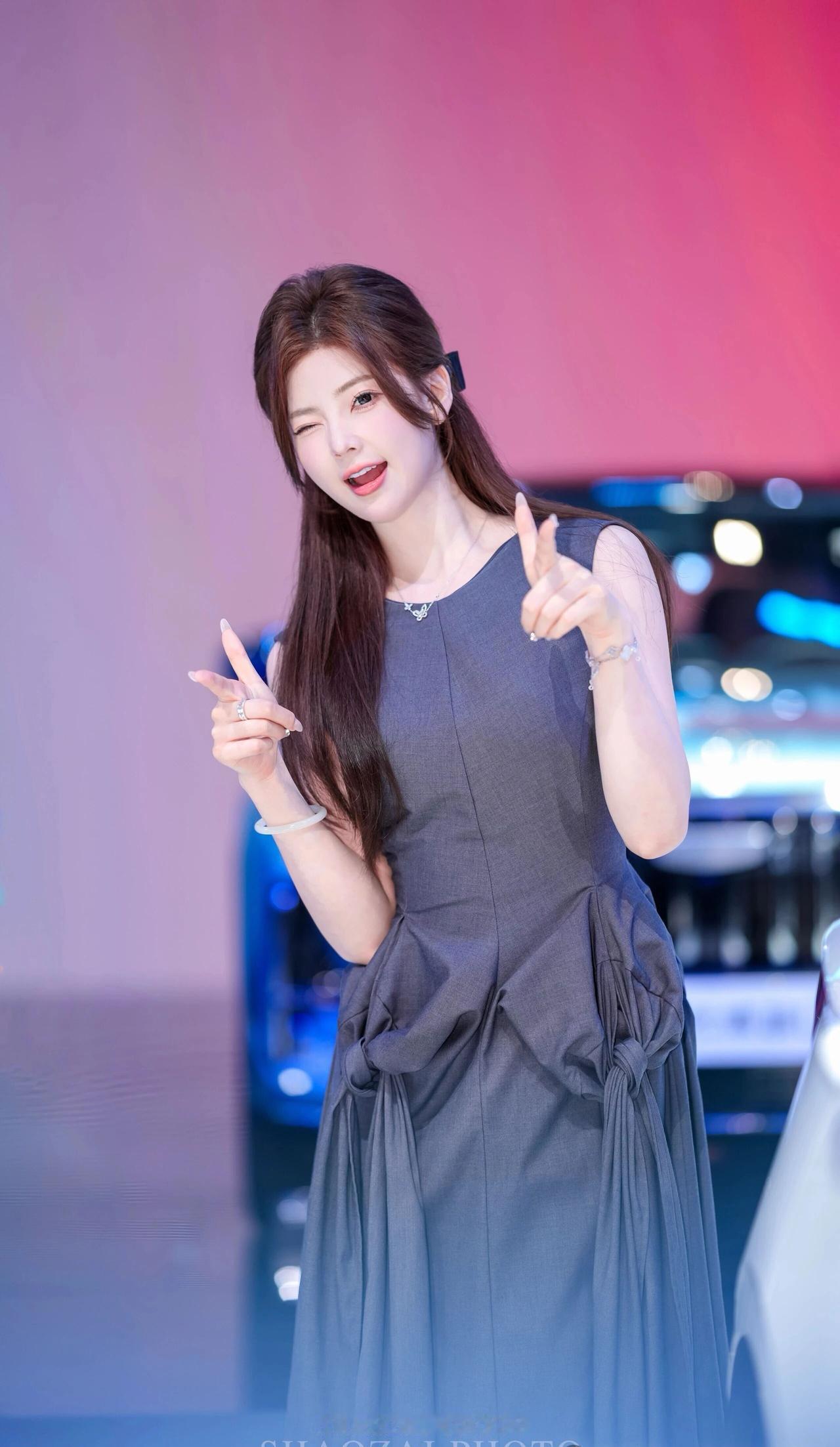 她留着一头柔顺的深棕色长发，用黑色蝴蝶结发夹半扎在脑后，几缕碎发垂在脸颊旁，衬得