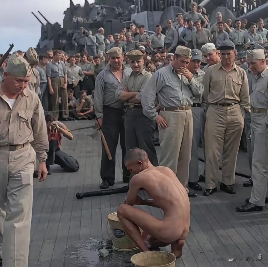 日本鬼子被美国大兵俘获后，美国大兵要求其在战舰甲板上洗澡，成群的美国大兵围观，这