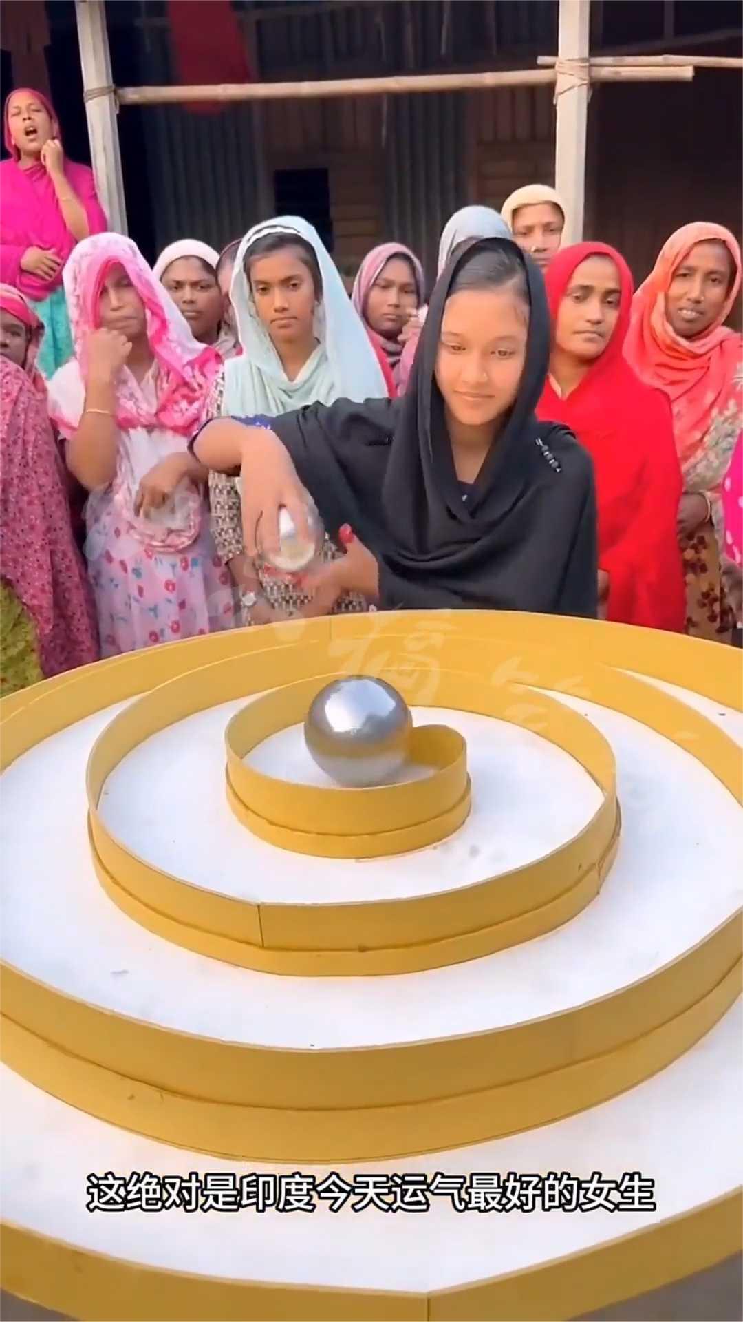 这绝对是印度今天运气最好的女生，只要能把篮子里这五个球随机顺着轨道滚动，最后顺利