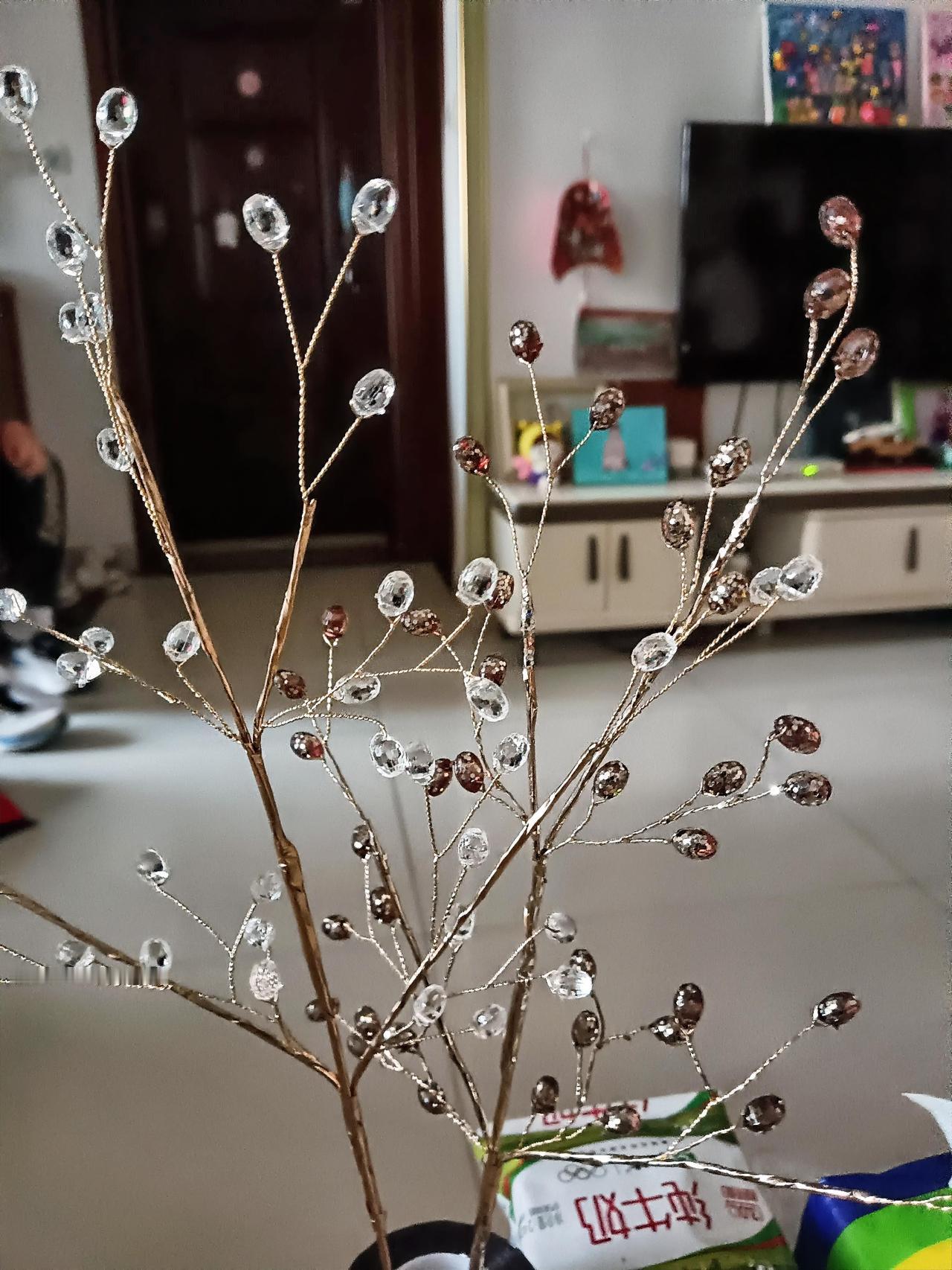 亮晶晶的水晶花枝，摆家里氛围感拉满。
细细的金色枝桠，缀满通透的水晶珠子，在光线