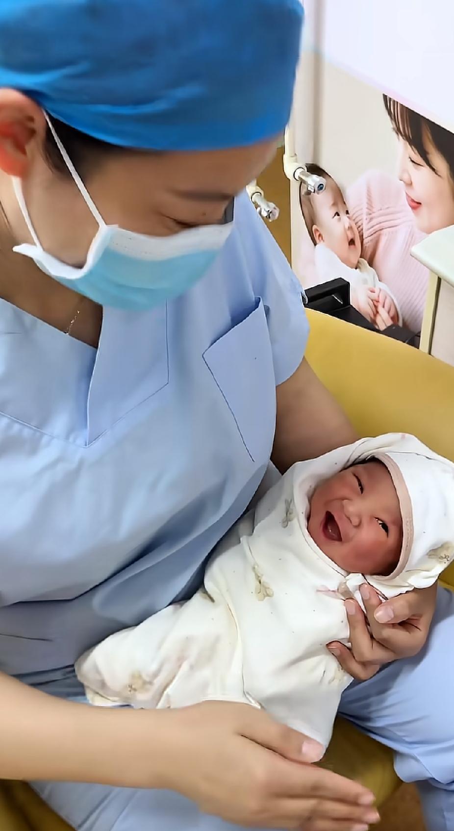 “这个宝宝不哭居然还笑了”。

抱着一个刚出生的宝宝，直接把接生的护士乐得哈哈大