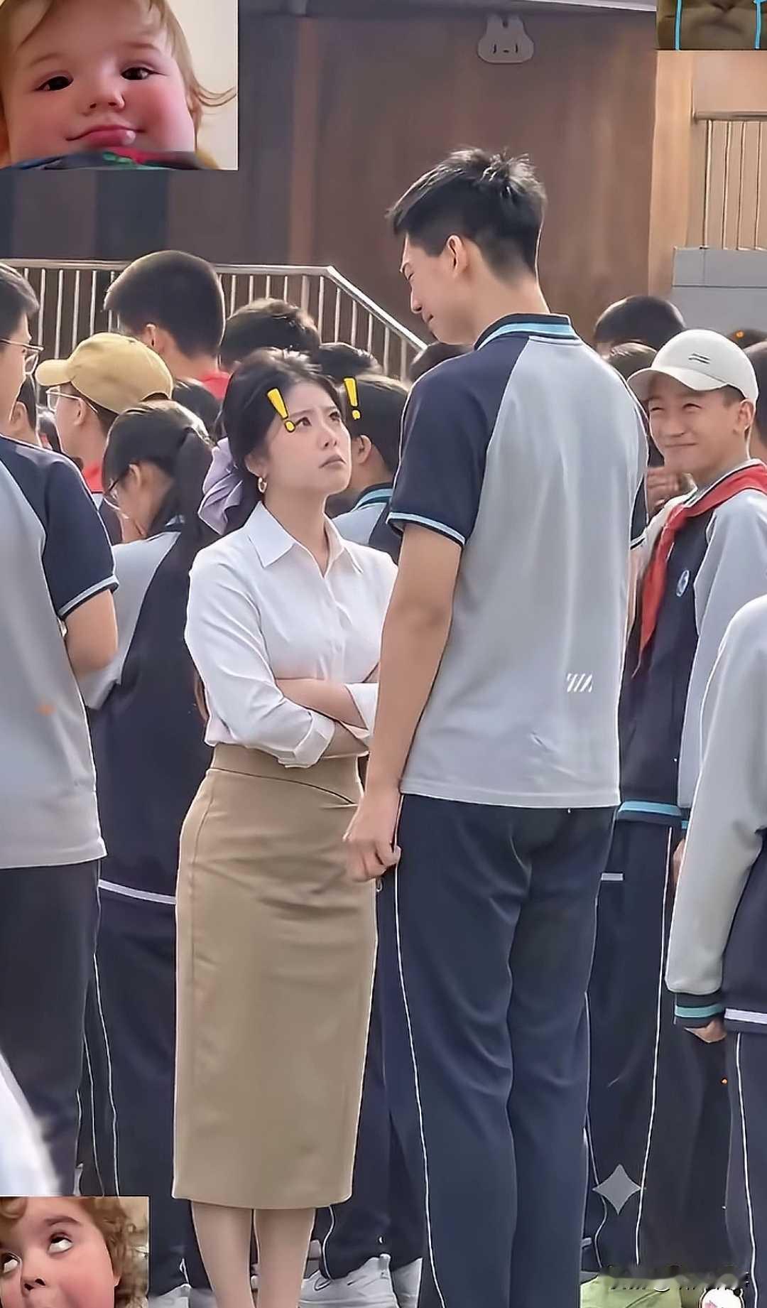 校园的操场上人群熙攘，列队的学生簇拥在四周。女老师身着干净白衬衫搭配卡其色半身裙