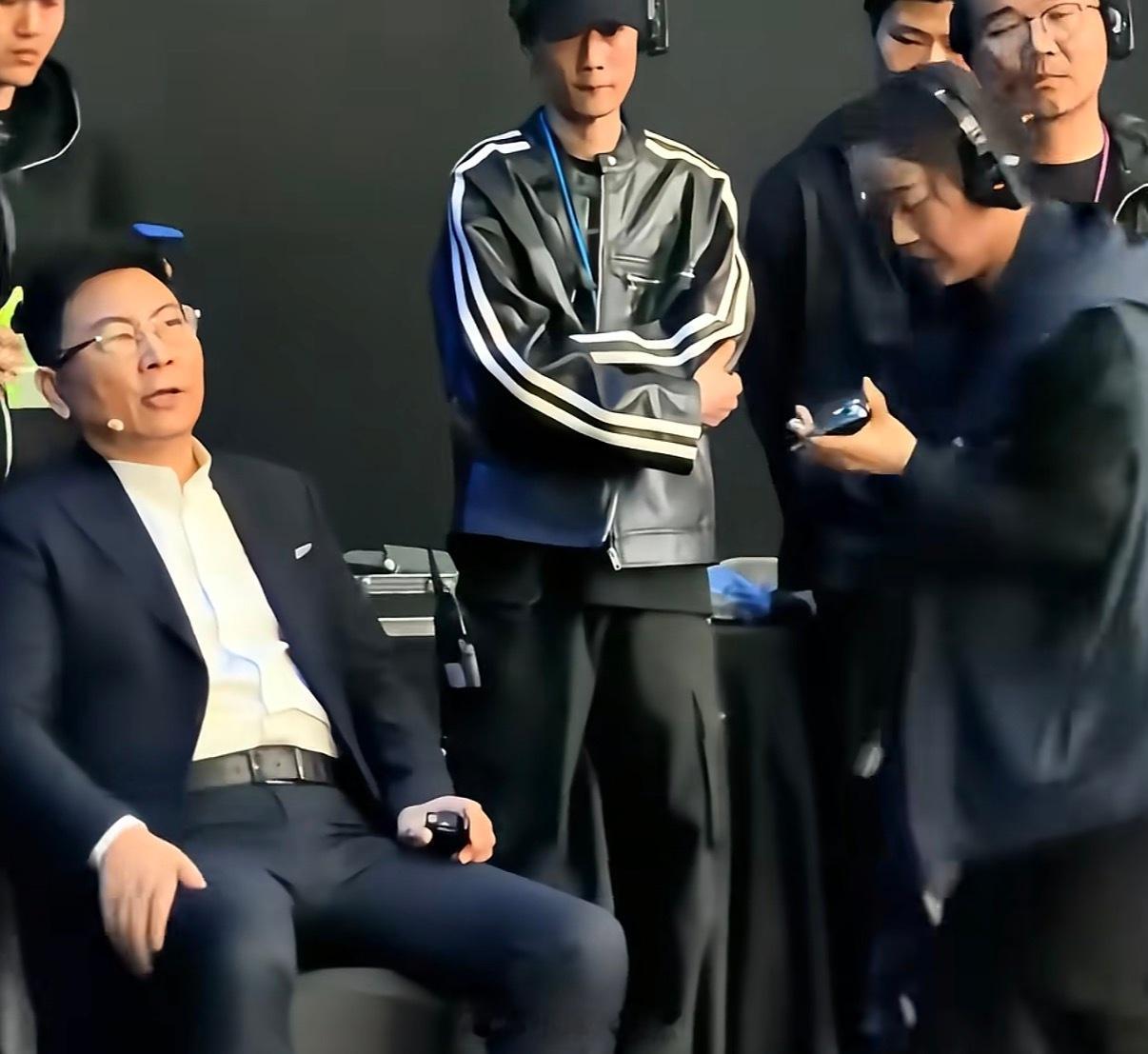 事情是这样的：在鸿蒙智行发布会前，有人拍到余承东坐在椅子上，一位工作人员半蹲着给