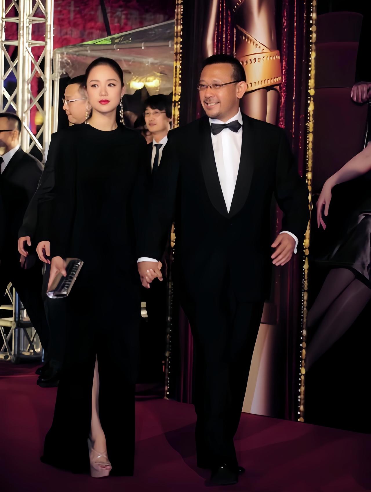 姜文携老婆周韵走红毯旧照，他牵着小15岁娇妻的手，笑的好开心啊。

而周韵身穿黑