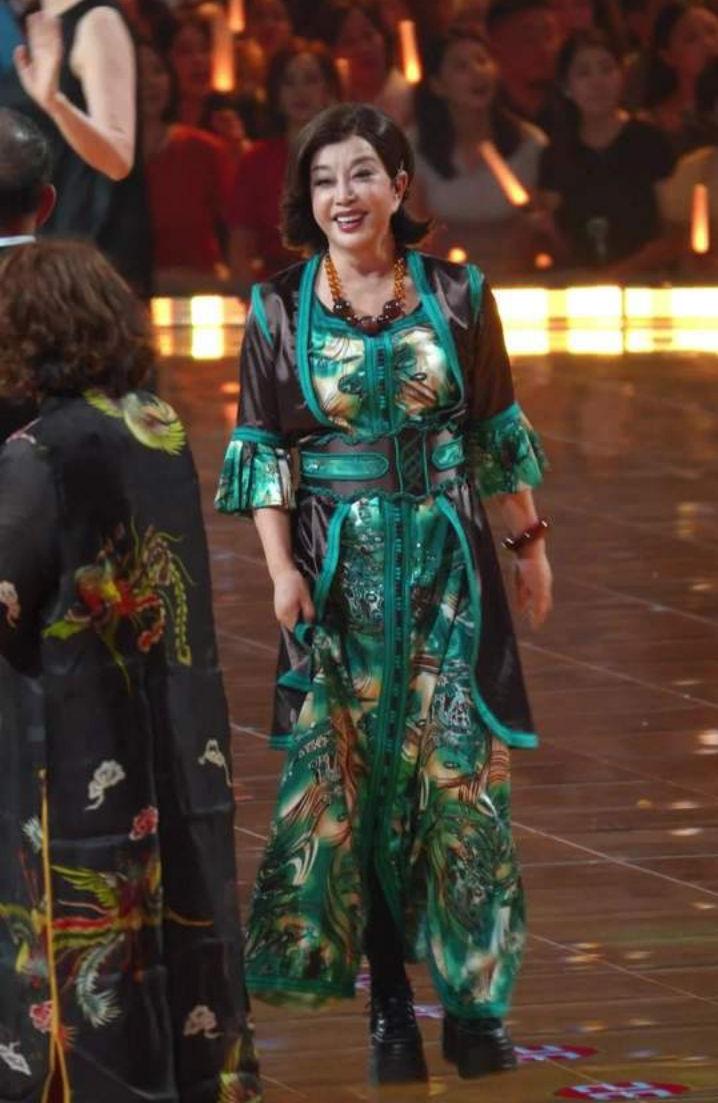 她穿着绿棕配色的国风长裙，裙摆随着脚步轻轻扬起，气场十足。
 
她大方挥手，和身