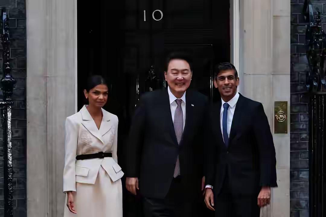尹锡悦身旁的女子是英国第一夫人，她的肤色好黑，和金建希的白成鲜明对比。