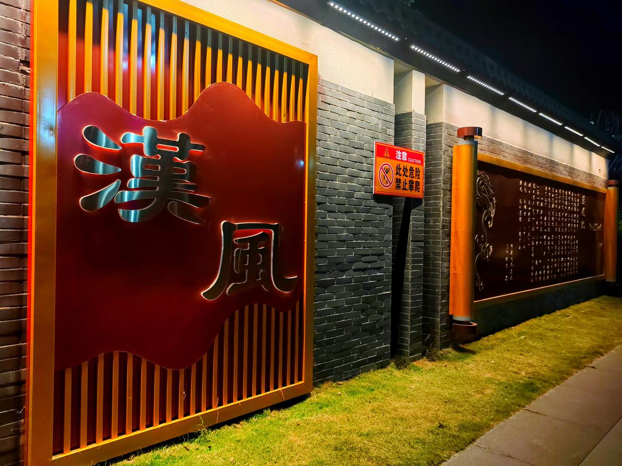 青砖映夜，灯影摇红。
汉风二字，静卧暖光里。
一卷书墙，藏着千年风雅。
夜色漫过