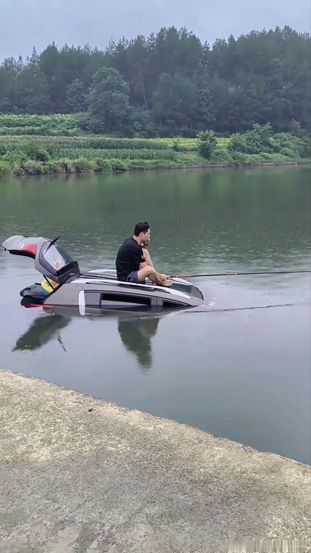 这哥们太淡定了，去钓鱼把车冲进河里了，索性就坐在车顶钓起鱼来，不过说实话，这种情