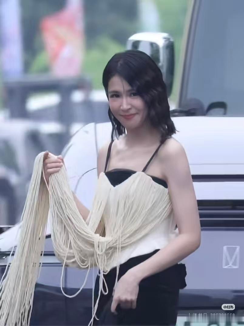 曾沛慈今晚饿了又有挂面又有泡面随手攥住一大束流苏，宛如提着一捆新鲜挂面，头上的卷