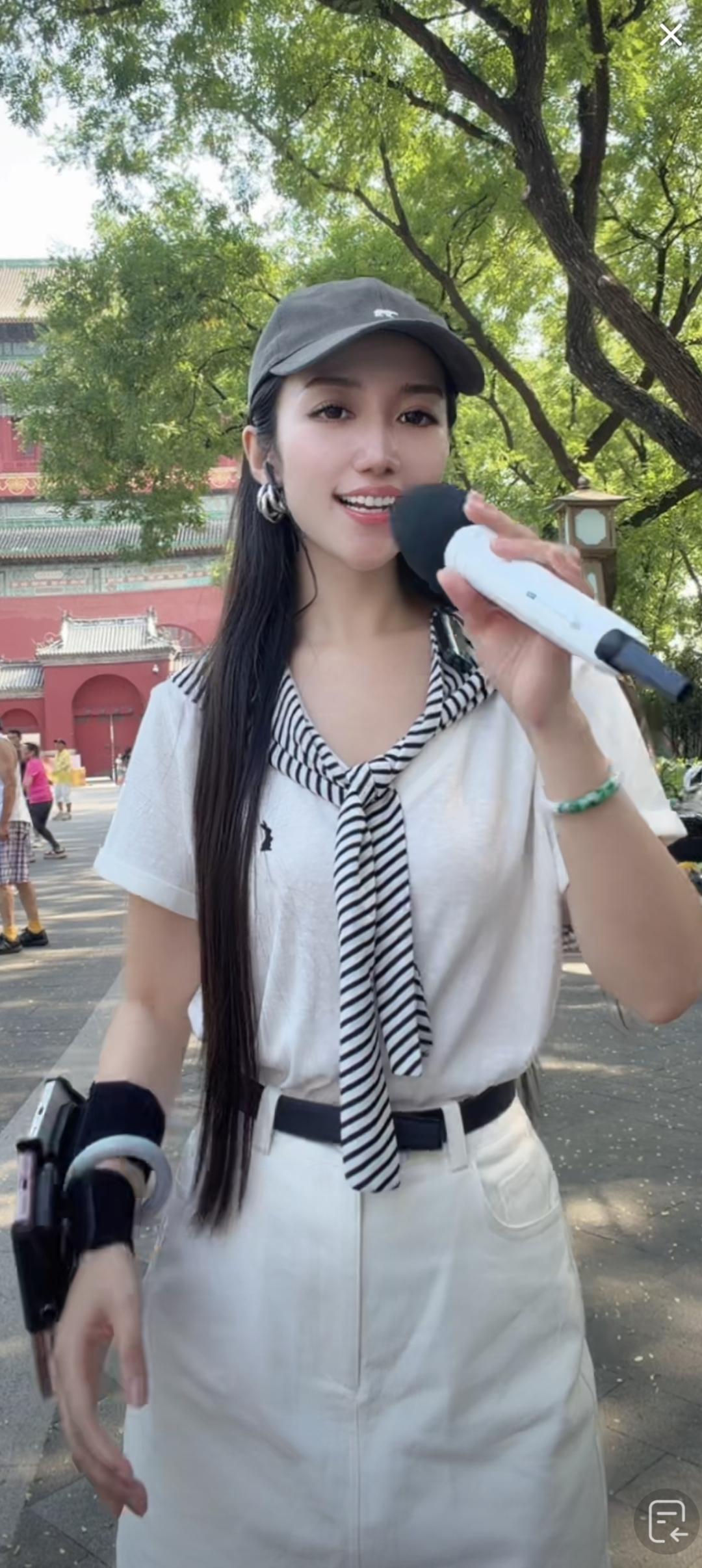 一个女孩在户外拿着麦克风。