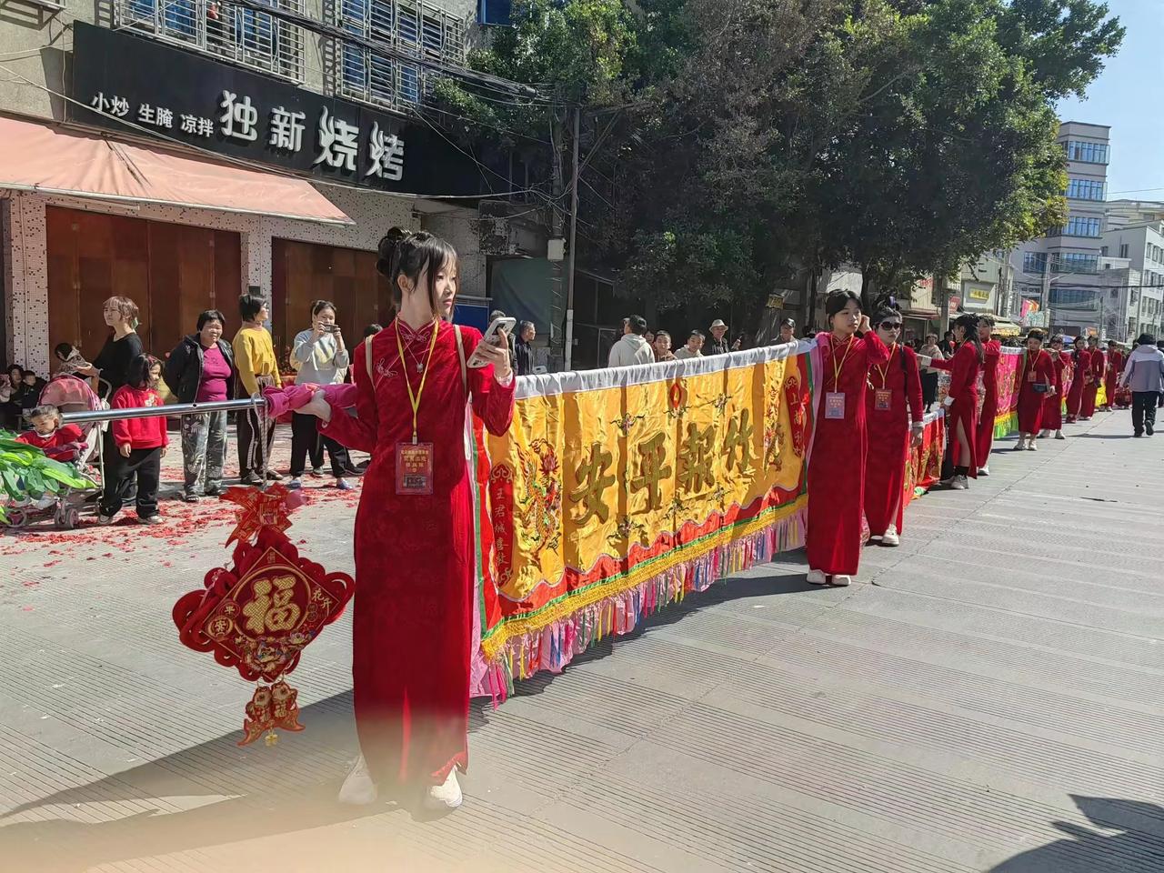 晒图笔记大赛潮汕民俗活动扛标旗的总是靓妹，而且穿的很舒服的旗袍，最吸引人的注目。