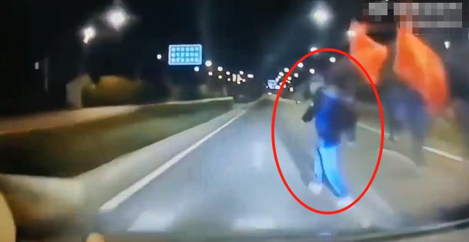 男子晚上开车回家，路遇霸占马路锻炼的暴走团。男子赶紧躲到最内侧车道行驶，可暴走大