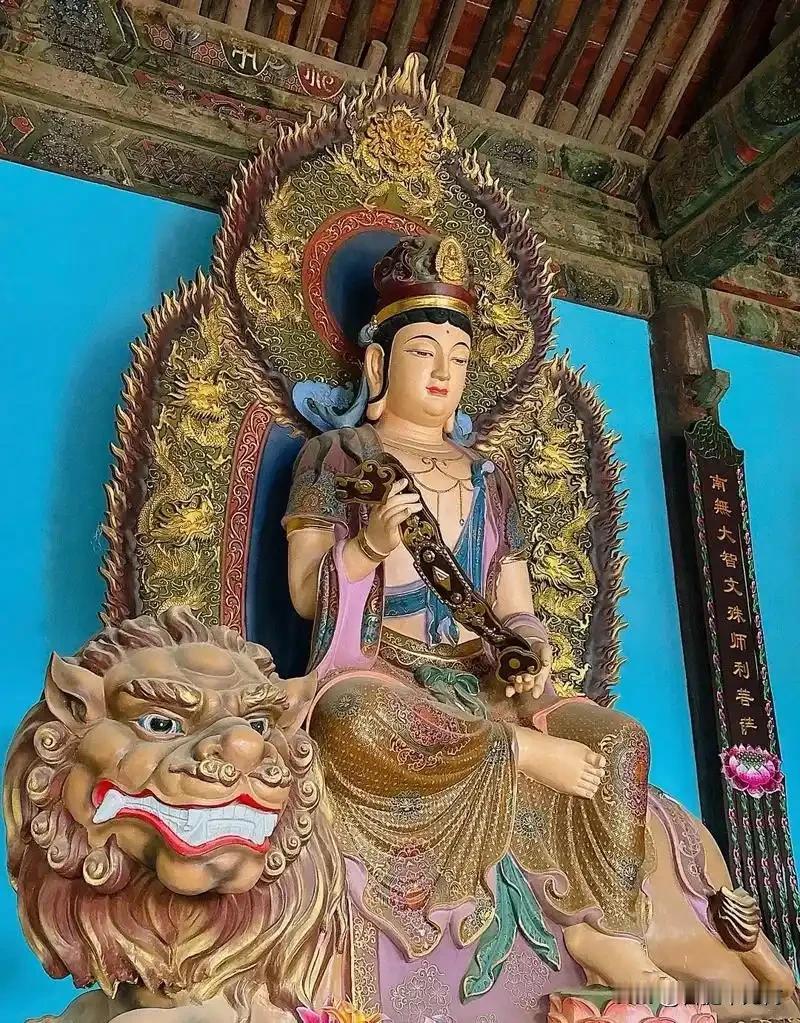大殿蓝墙映金身，金龙背光衬慈悲，文殊菩萨稳坐青狮，手握如意，静静渡每一个心怀期许
