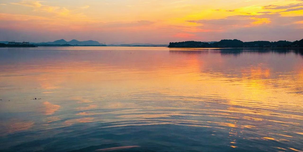 藏在芜湖龙窝湖落日里的湖景烧烤店太治愈了

傍晚的龙窝湖把橘色晚霞铺在水面上，风