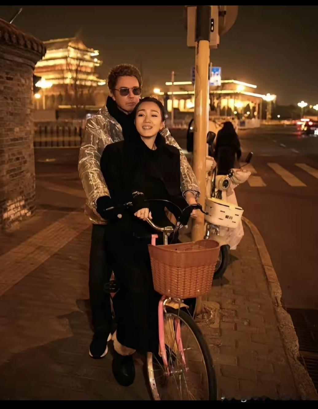 京城的夜色晕染开暖黄的光，60岁的巩俐和77岁的丈夫骑着单车穿行在老街，两人依偎