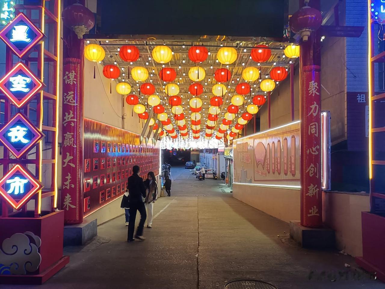 夜晚的繁华街景，红灯笼与霓虹灯交相辉映，热闹非凡。