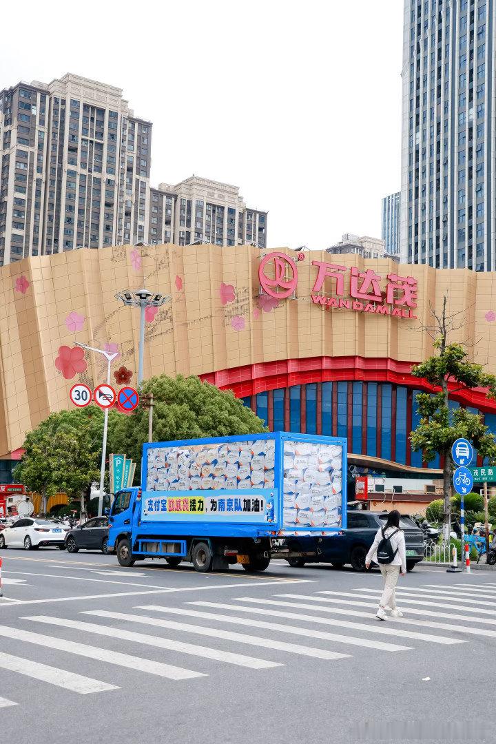百店发支付宝助威袋为南京队加油要说现在南京人去哪？不是撞见支付宝大卡车，就是忙着