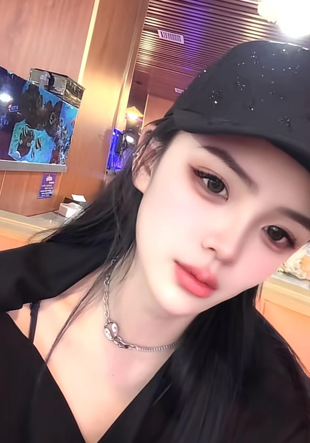 在灯光的笼罩下，她周身散发着迷人的光彩，宛如夜晚降临的精灵。她的眼神灵动活泼，似