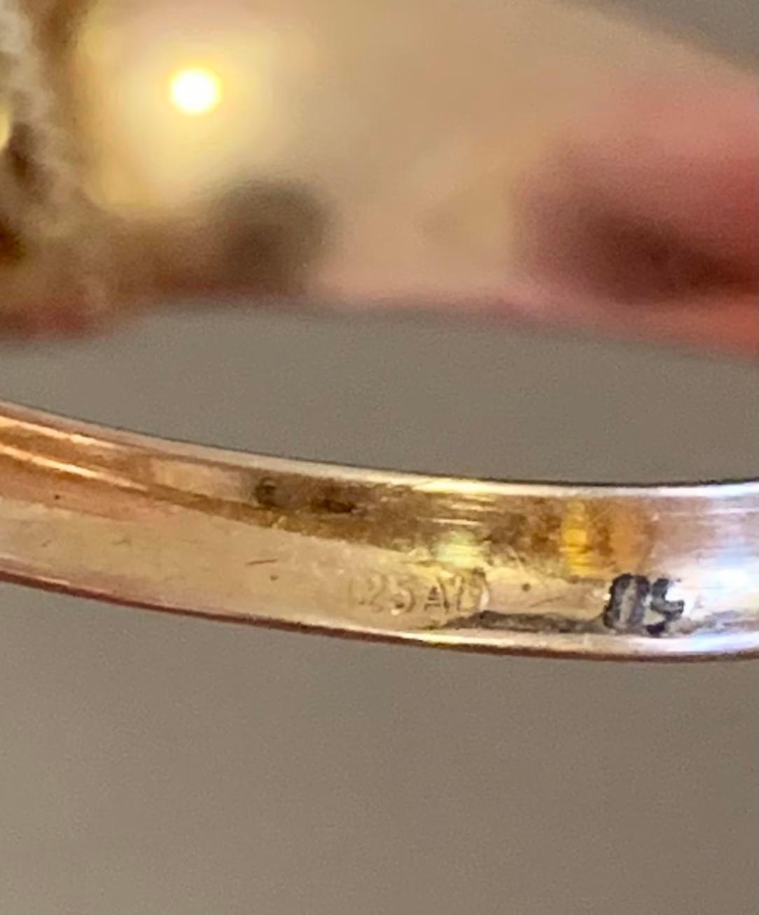 周末帮领导搬家，从沙发缝隙里抠出个戒指。金色托子绞着麻花绳纹，中间镶颗马眼形橙黄