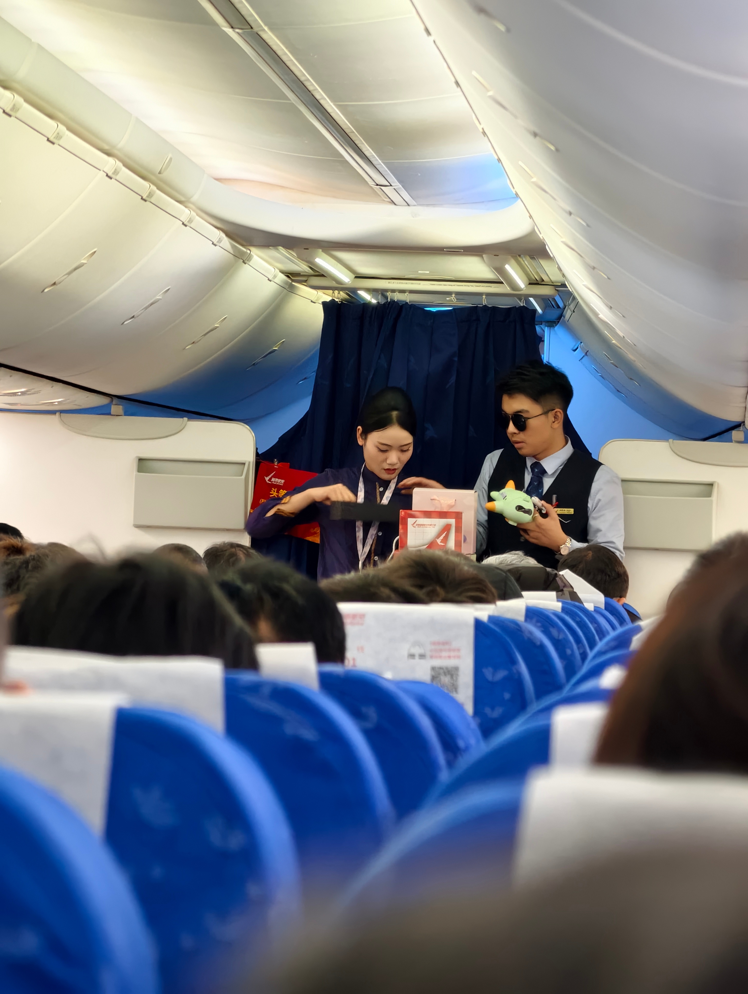 我还是第一次在飞机上看到产品推销了，卖飞机模型，墨镜，还有飞机模型玩偶啥的 