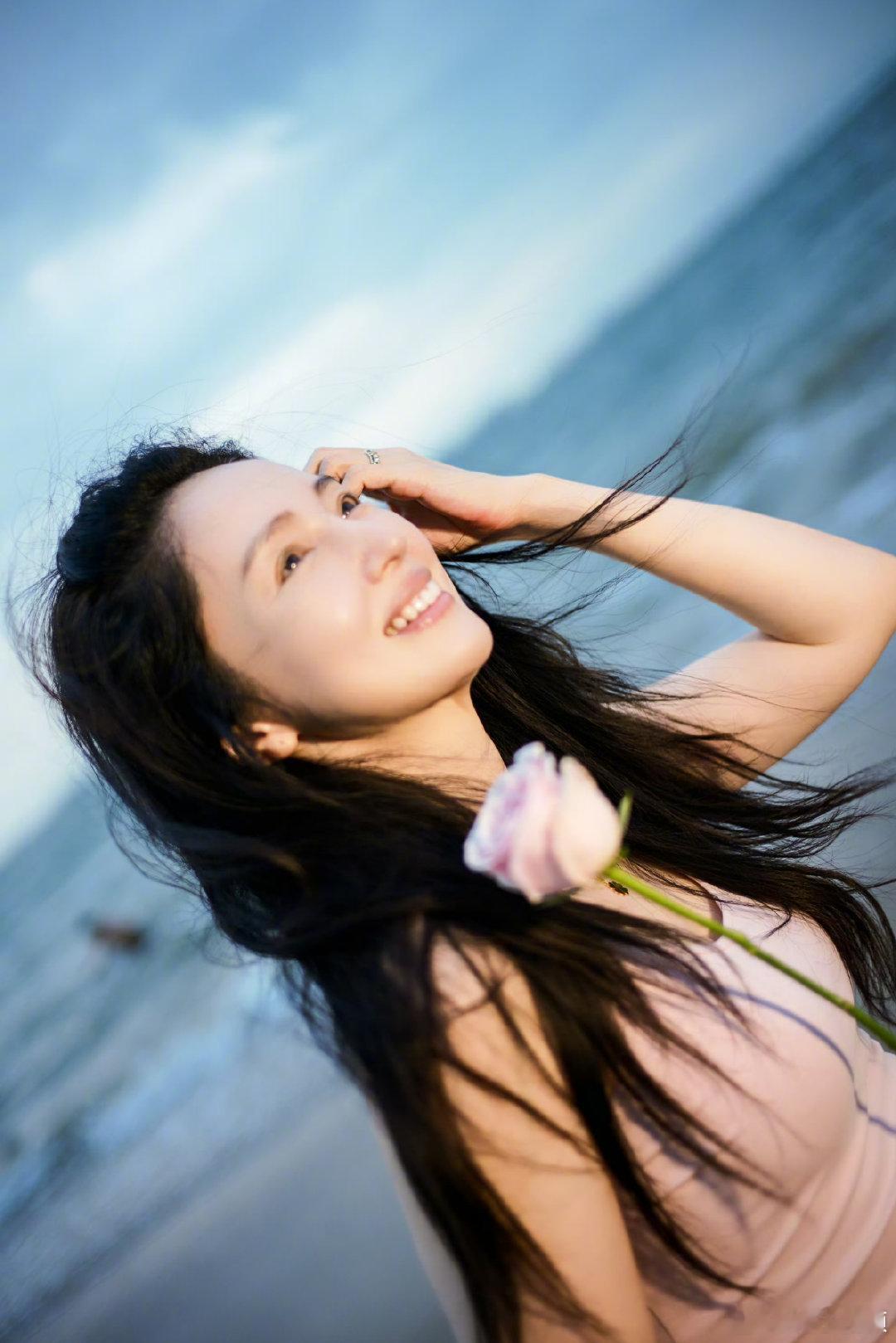 董璇头戴玫瑰随拍 海边黄昏搭配耳边粉玫瑰，素颜怼脸拍好能打，整个人温柔又松弛 ，