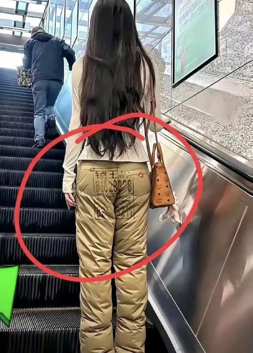 这其实是一个非常有创意的“错位广告”设计，并不是女孩真的“坐”在了二维码上。
