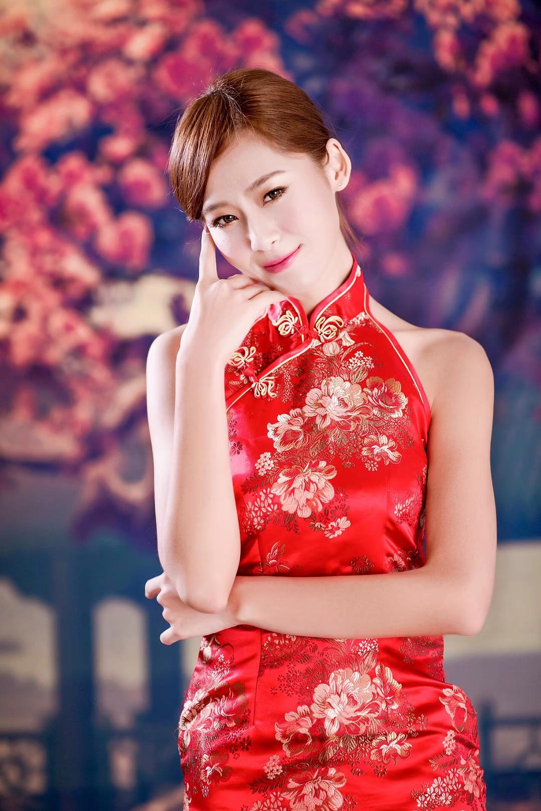 她身着一袭赤霞熔金般的红色旗袍，裙摆如焰火绽放，每一寸丝绸都流淌着千年东方美学的