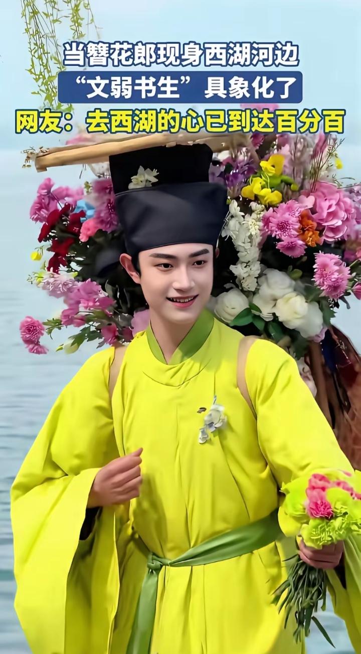 被西湖这位簪花郎惊艳到了，他皮肤很白，眉清目秀，一身亮眼的黄袍子，头上簪着花，背