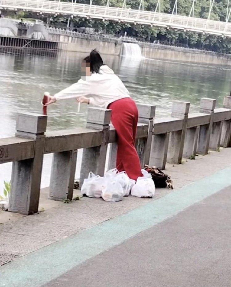 简直荒唐！据5月13日红星新闻报道，在贵阳南明河畔，一名白衣红裤的女子拎着六大袋