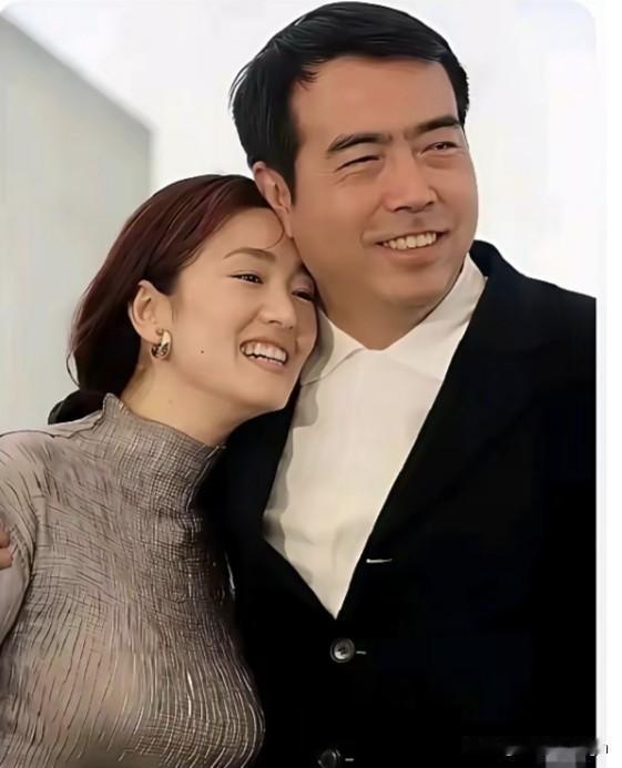 巩俐脑袋轻轻歪在陈凯歌的肩上，两人就这么挨着，好像很亲密的样子。两人都笑得特别灿