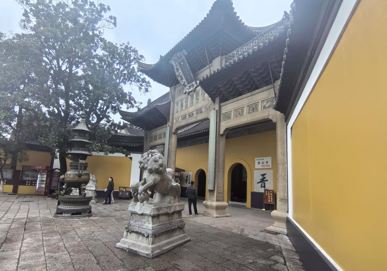 【七绝·登金山】
细雨秋山湿客衫，
江涛隐雾绕危岩。
登临未叹风光寂，
一杵钟声