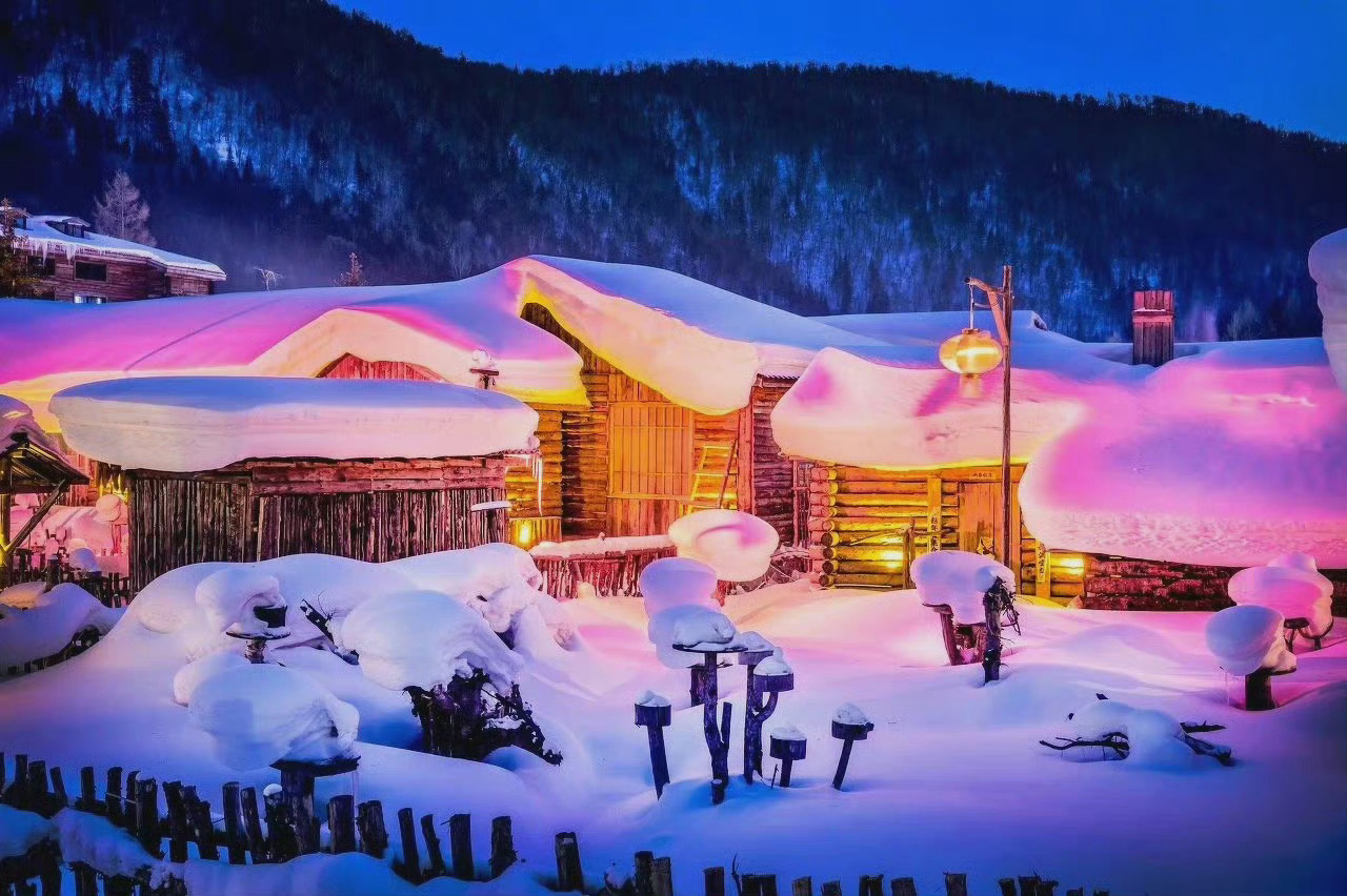 夜色下的雪乡，温暖的灯光透过屋子窗花之间的缝隙，撒向漆黑的雪地，交织出雪乡柔美的