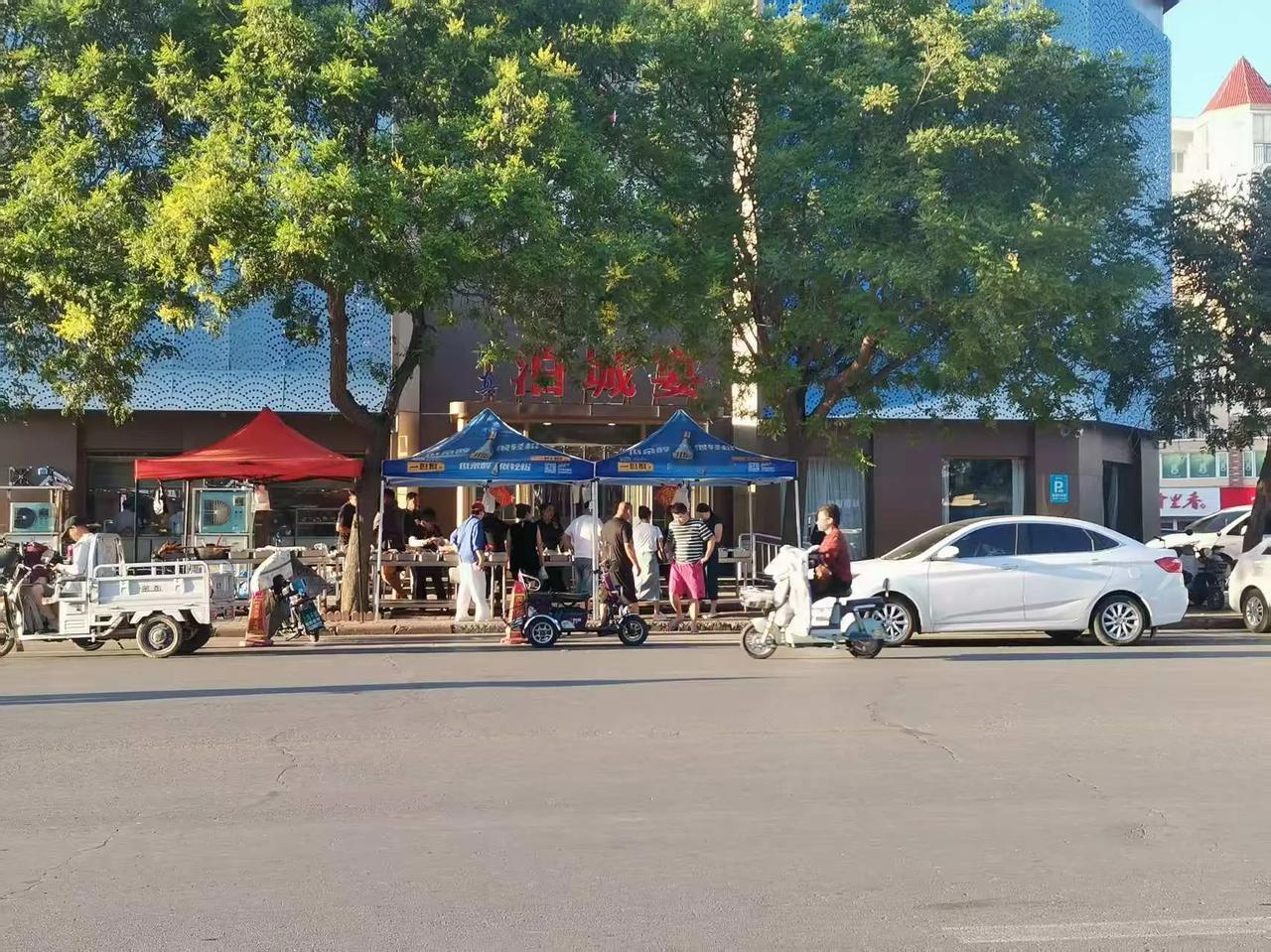 不知咋回事，往日车水马龙的大饭店门口，忽然摆开了一溜摊位，带着大白高帽子的大厨，