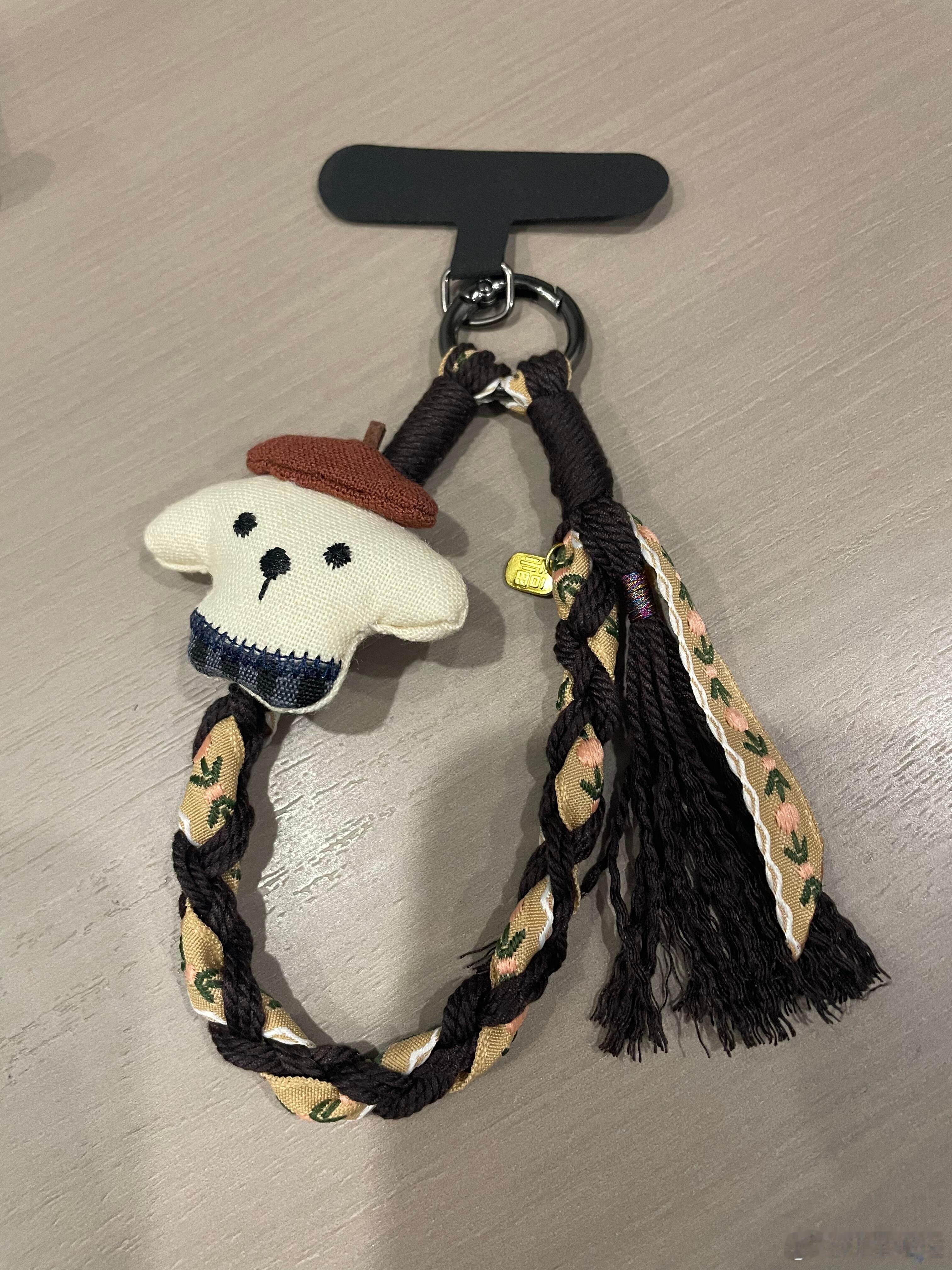 这款白色小狗造型的布艺挂饰，头戴棕色贝雷帽，颈系深蓝格纹围巾，憨萌表情尽显可爱。