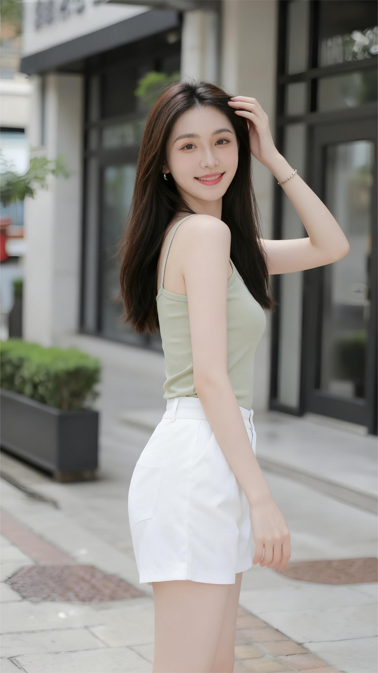 《街角的绿意》
她站在街角，
像一缕风穿过城市。
浅绿吊带轻贴肩，
白短裤收住阳