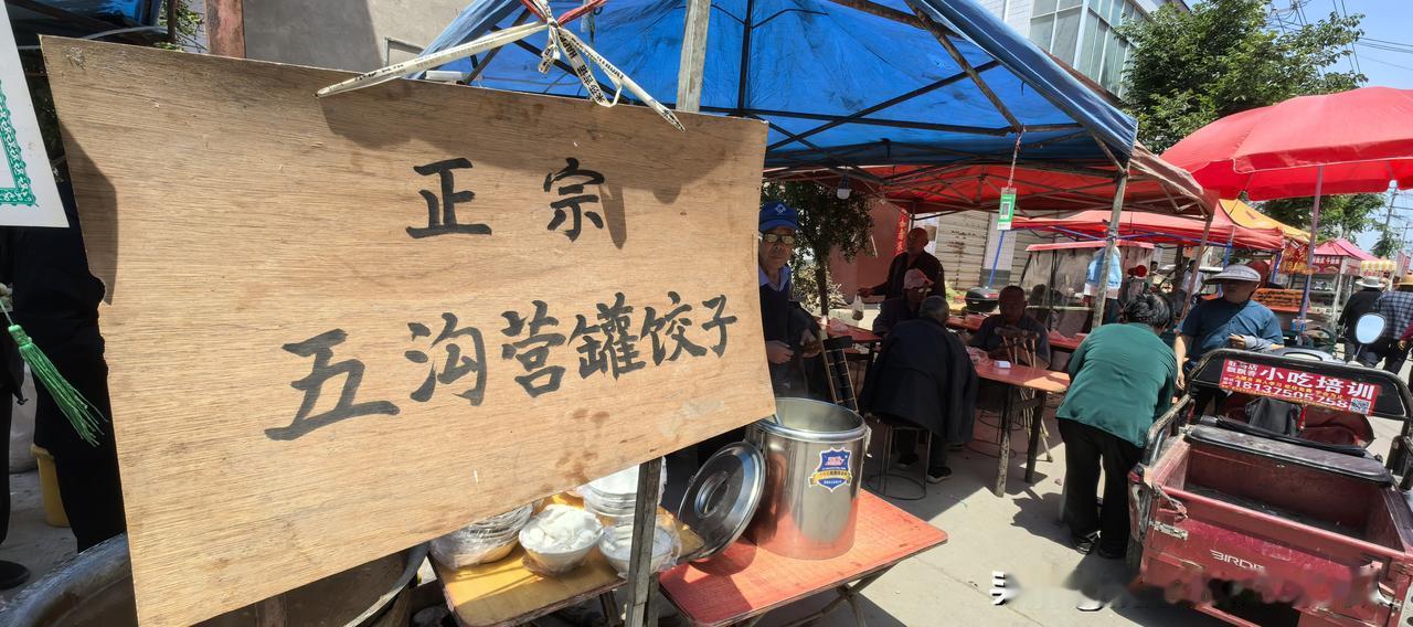前几天，沱沟村会上，在众多设摊位卖吃食的，我看到一家悬挂木牌子的摊位。牌子上写着