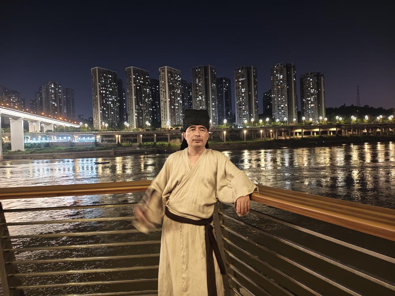 五律•夜临嘉陵江所感
〔当代〕邹謇

暮色笼江渚，凭栏意自闲。
衣巾追古意，楼厦