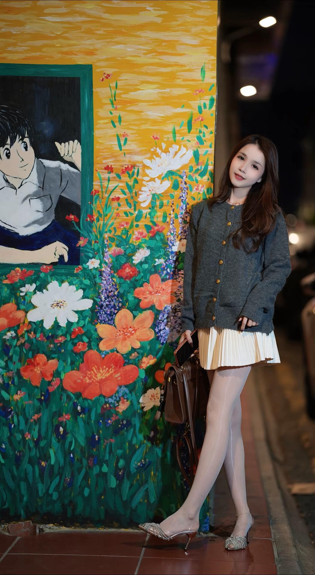 这张图片呈现了一位女性在夜晚街头的场景，结合图片细节展开描述：

 人物形象与穿