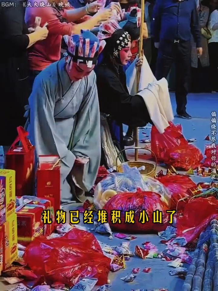 戏曲演出结束，戏迷上台打赏现金超十万。
演出中观众扔了一包东西，演员以为自己没演