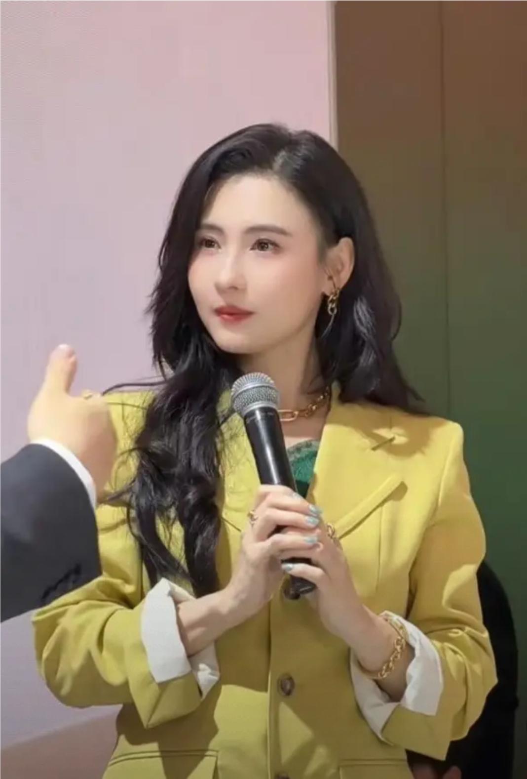45岁张柏芝亮相上海活动，一身月牙黄西装看起好清爽，戴着黄金项链，手链，大波浪长