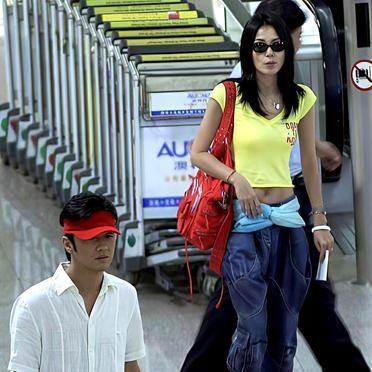 王菲36岁，李亚鹏34岁。
蜜月刚结束，两个人走在路上互相逗乐。
她穿了件浅黄色