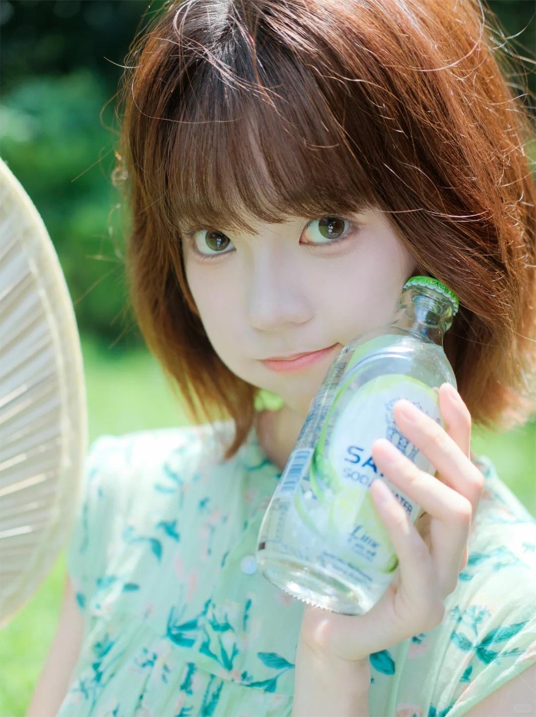 女孩拿着soda饮料，微笑看镜头。河边戏水，笑意盈盈