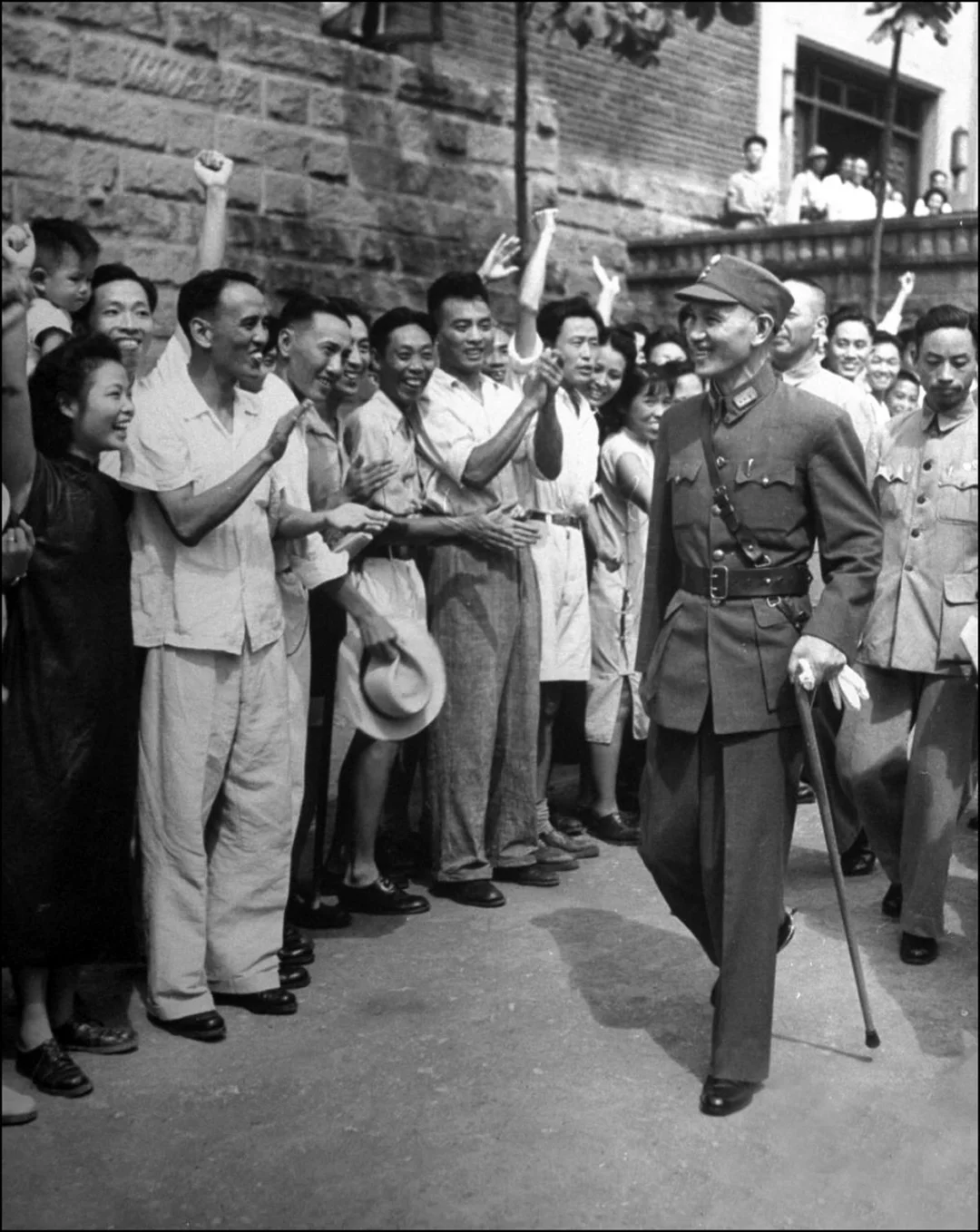 1945年9月3日，重庆，日本投降后半月余，蒋中正拄着手杖步出，受到重...