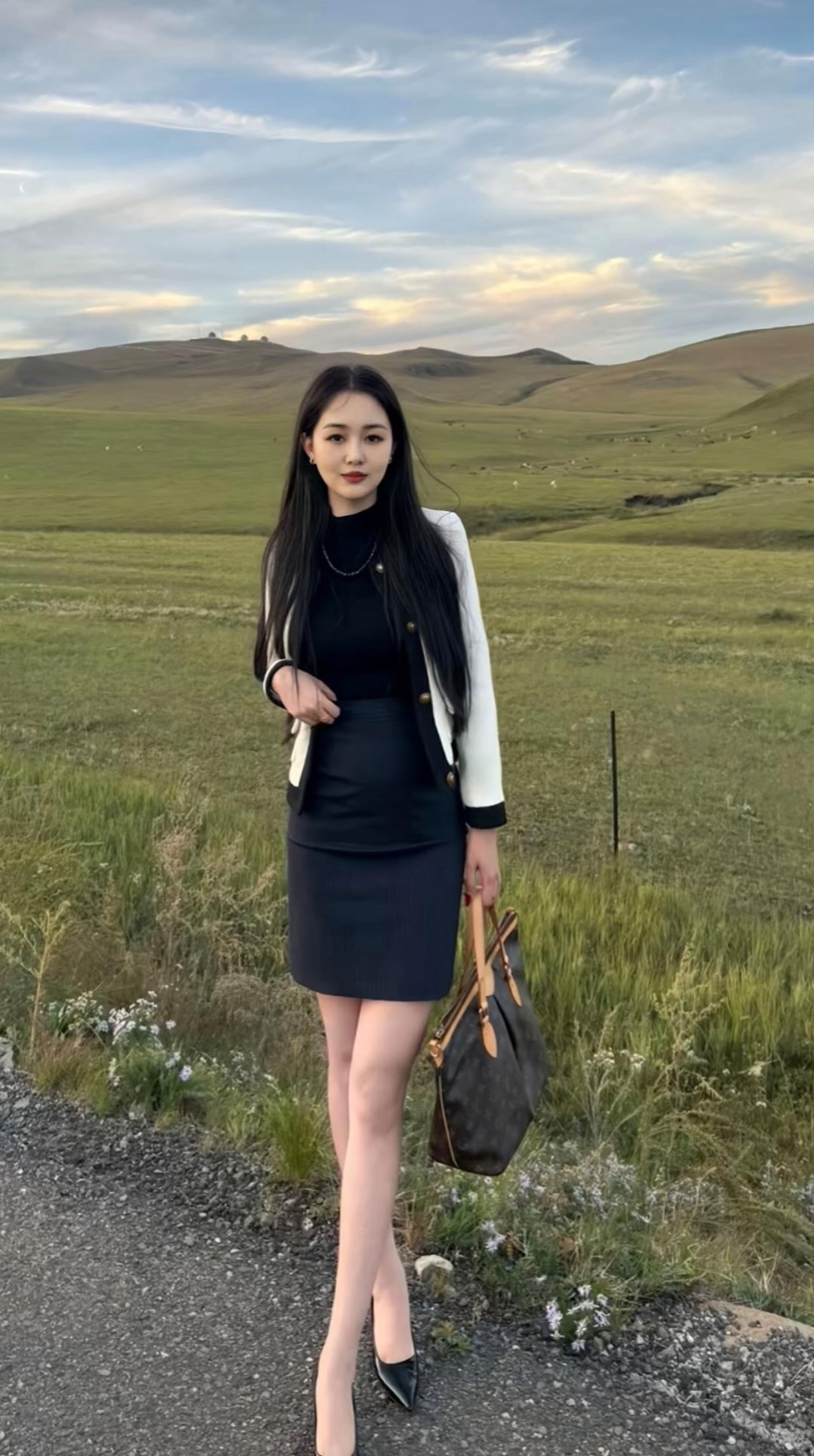 草原上的时尚女郎，黑裙白衣，优雅动人。