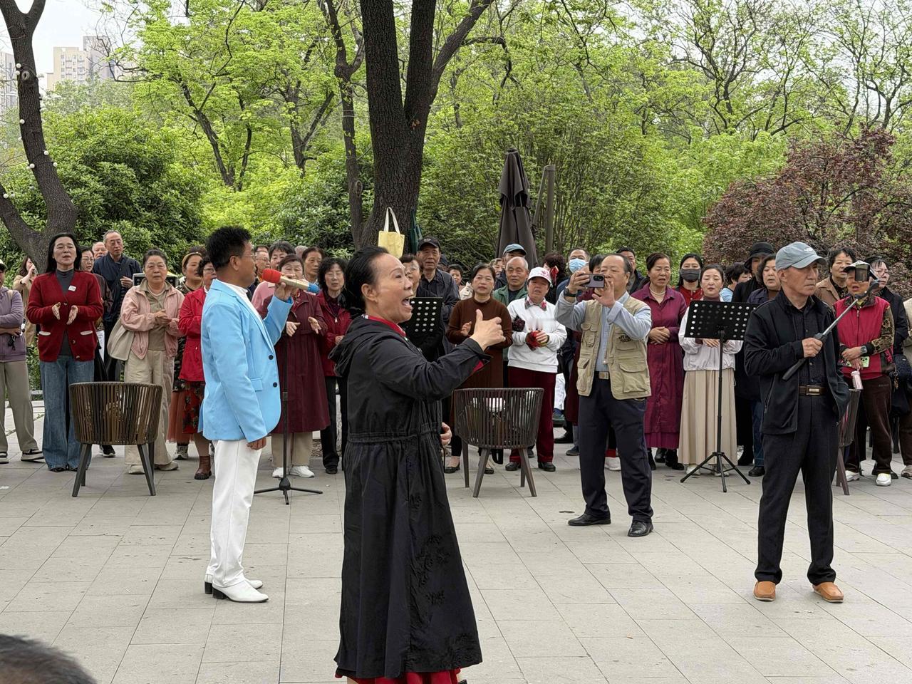 今天上午，我逛兴庆宫公园，走到沉香亭北面的假山旁时，听到有人说上面唱歌的热闹！